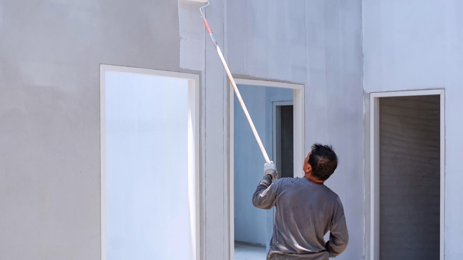 Painter rolling fresh paint onto a wall by a painting contractor in West Valley City, UT